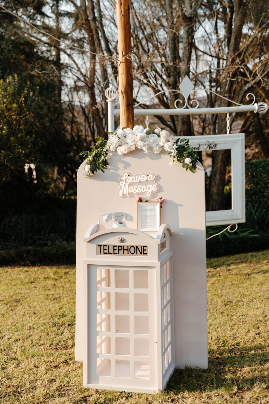 A white wedding telephone booth with roses, booked through Genesis Pro